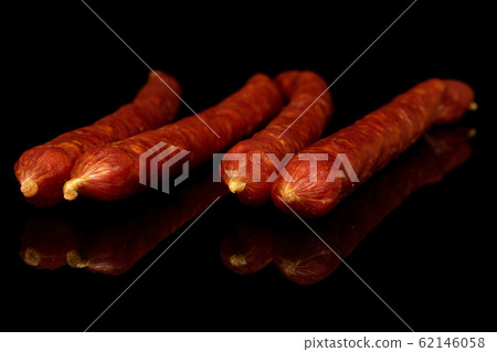 Smoked spicy sausage isolated on black glass Smoked spicy sausage isolated on black glass 62146058