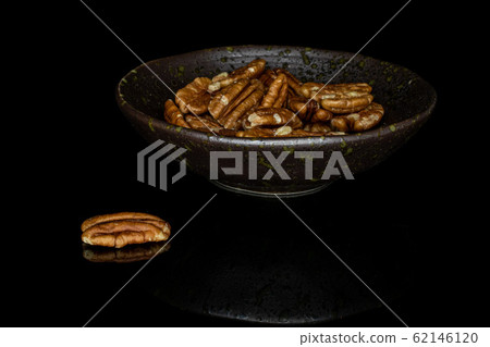 Brown pecan nut isolated on black glass Brown pecan nut isolated on black glass 62146120