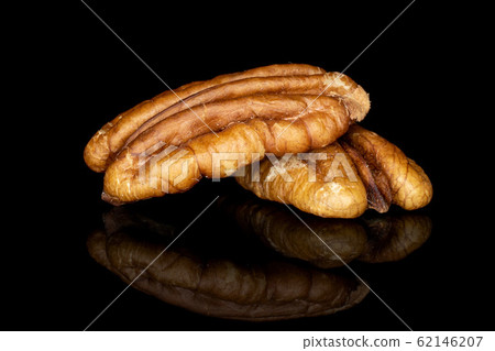 Brown pecan nut isolated on black glass Brown pecan nut isolated on black glass 62146207