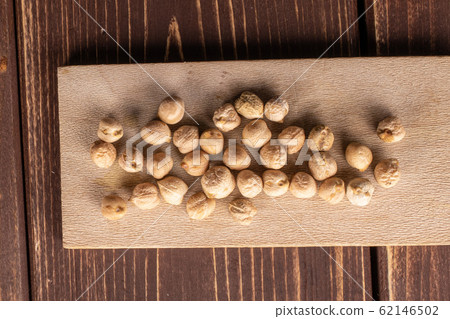 Fresh tan chickpea on brown wood 62146502