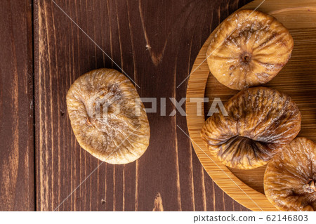 Dried fig fruit on brown wood Dried fig fruit on brown wood 62146803