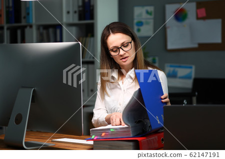 Woman opened folder with documents examines them 62147191