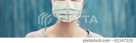 young woman in medical face protection mask indoors on blue background 62147229