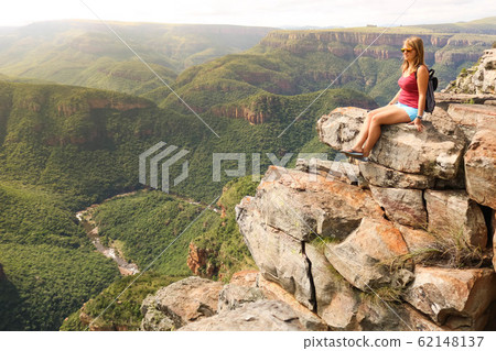 female hiking tourist sitting on mountains and enjoying the view female hiking tourist sitting on mountains and enjoying the view 62148137