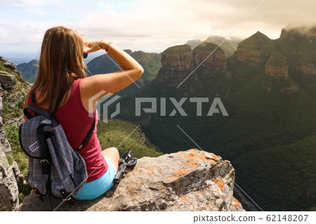 female hiking tourist sitting on mountains and enjoying the view 62148207