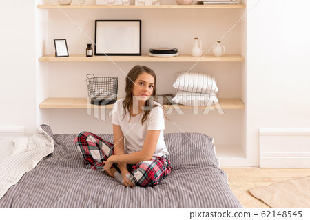 Elegant woman in home clothing resting on bed 62148545