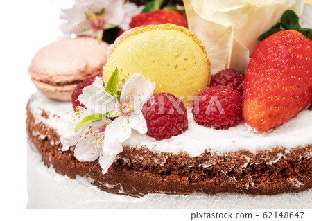 Naked birthday cake with almond flower fruits and marshmallows. Close-up. 62148647