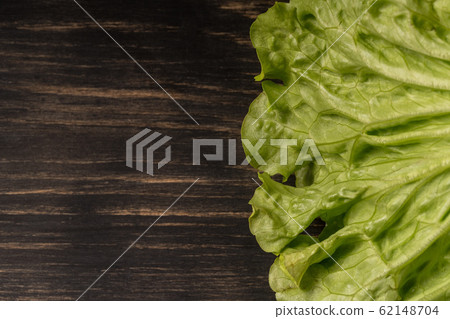 Lettuce salad on a dark wooden background, with place for copy space. Ffor vegetarians Lettuce salad on a dark wooden background, with place for copy space. Ffor vegetarians 62148704