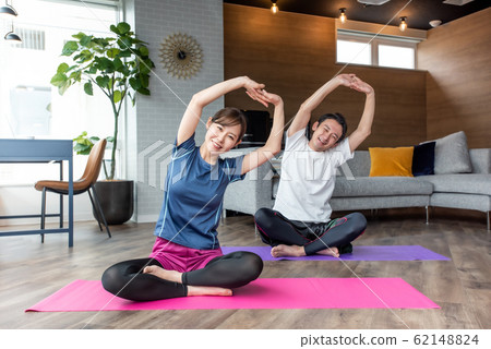 Yoga stretching in the living room at home Yoga stretching in the living room at home 62148824