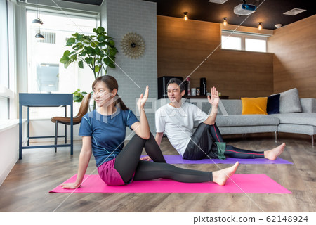 在家裡的客廳裡伸展瑜伽 在家裡的客廳裡伸展瑜伽 62148924