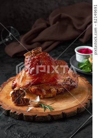 Roasted pork knuckle eisbein with cabbage and mustard on wooden cutting board 62149691