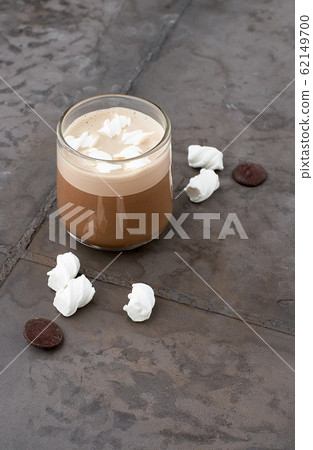 Cup of coffee with caramel topping and marshmallows on grey table Cup of coffee with caramel topping and marshmallows on grey table 62149700