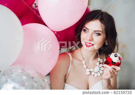 Smiling bride-to-be with muffin at her hen party. 62150720