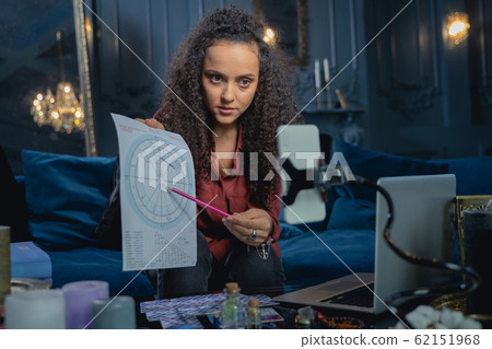 Focused young lady showing her astrological forecast Focused young lady showing her astrological forecast 62151968