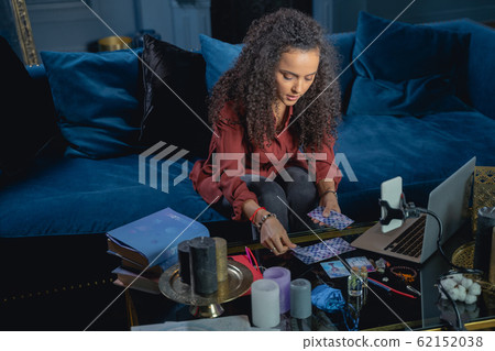 Young female laying out the tarot cards Young female laying out the tarot cards 62152038