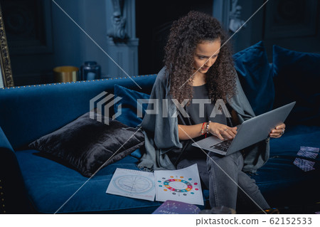 Young pretty female astrologer surfing the net 62152533