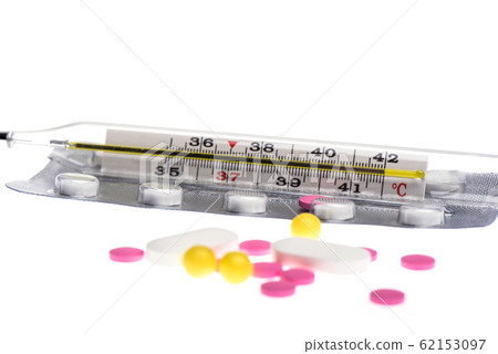 Selective focus. Glass mercury thermometer on a blister with pills isolated on a white background. Selective focus. Glass mercury thermometer on a blister with pills isolated on a white background. 62153097