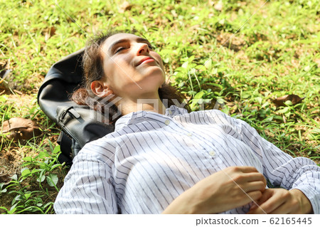 Beautiful woman sleeping relaxation on green grass Beautiful woman sleeping relaxation on green grass 62165445