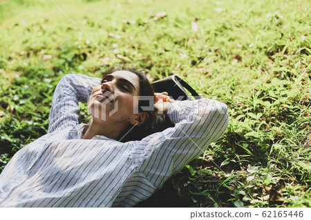 Beautiful woman sleeping relaxation on green grass Beautiful woman sleeping relaxation on green grass 62165446