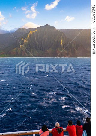 The Na Pali Coast and its sandy beaches shimmer in the sunlight – a breathtaking view of Kauai, Hawaii. The Na Pali Coast and its sandy beaches shimmer in the sunlight – a breathtaking view of Kauai, Hawaii. 62168043