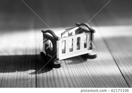 Empty crib on a wooden background Empty crib on a wooden background 62173106