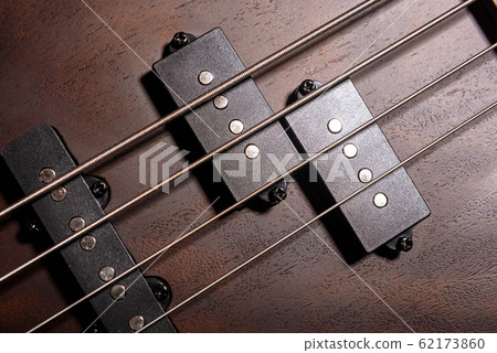 Bass electric guitar with four strings closeup.