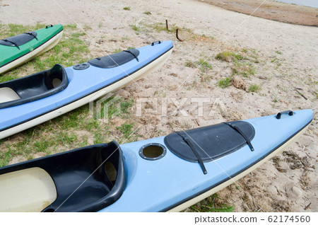 A lot of blue and green canoe kayaks 62174560