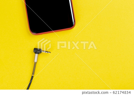 Close-up Jack plug and a cable with phone on a Close-up Jack plug and a cable with phone on a 62174834