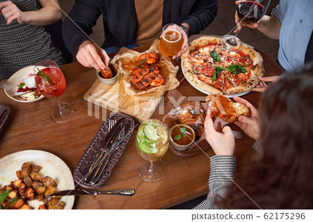 Group of europeian friends enjoing food for one big table Group of europeian friends enjoing food for one big table 62175296