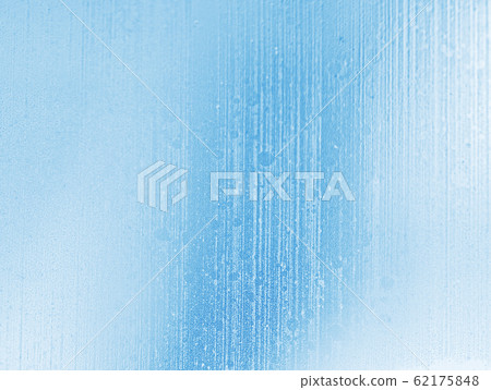 Winter blue and white blurred background of frozen streams of water on window glass. Blue toned natural abstract background. Winter blue and white blurred background of frozen streams of water on window glass. Blue toned natural abstract background. 62175848