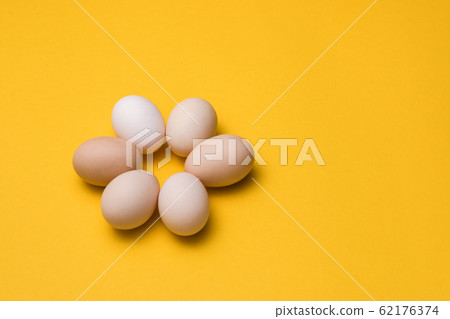 natural ecological eggs in shape of flower on yellow background with copy space. happy easter 62176374