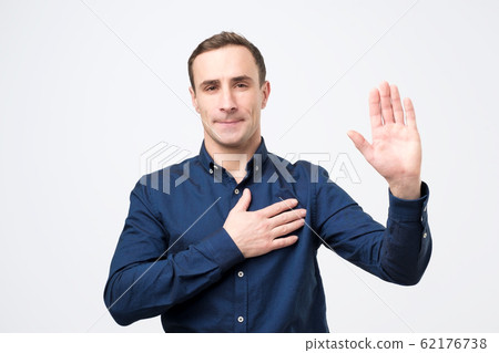 Sincere happy man raising palm and holding hand on chest, promising to me honest 62176738
