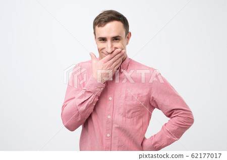 Ridiculously funny prices. Cheerful caucasian man laughing and covering mouth with palm, hearing funny joke. Ridiculously funny prices. Cheerful caucasian man laughing and covering mouth with palm, hearing funny joke. 62177017