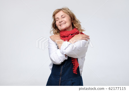 Funny mature woman hugging herself being selfish. 62177115