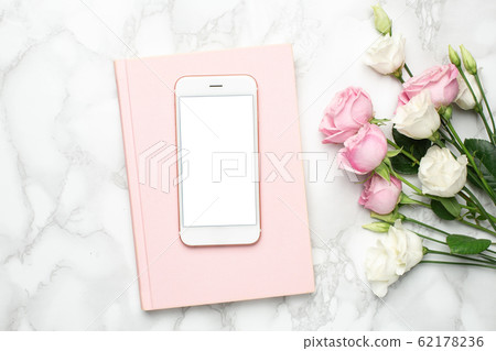 Mobile phone with pink and white roses flowers on marble background.Minimalistic composition for the holidays,valentines day and womens day. 62178236
