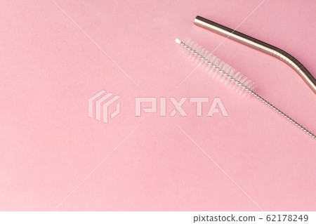 Metal, bendy drinking straw and steel cleaning brush on pink background. Aluminum stainless reusable bar equipment for drink alcohol cocktails, water or lemonade. Eco friendly alternative Metal, bendy drinking straw and steel cleaning brush on pink background. Aluminum stainless reusable bar equipment for drink alcohol cocktails, water or lemonade. Eco friendly alternative 62178249