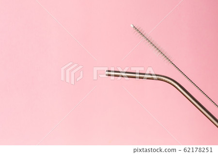 Metal, bendy drinking straw and steel cleaning brush on pink background. Aluminum stainless reusable bar equipment for drink alcohol cocktails, water or lemonade. Eco friendly alternative Metal, bendy drinking straw and steel cleaning brush on pink background. Aluminum stainless reusable bar equipment for drink alcohol cocktails, water or lemonade. Eco friendly alternative 62178251