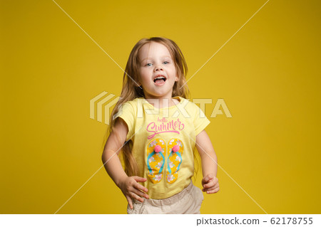 Longhaired girl in cute shirt playing with hair Longhaired girl in cute shirt playing with hair 62178755