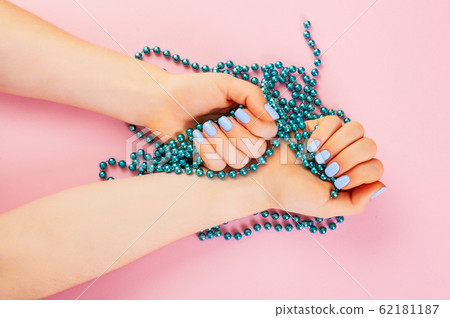 Stylish trendy female manicure. Beautiful young woman's hand with perfect blue manicure on pink background. Stylish trendy female manicure. Beautiful young woman's hand with perfect blue manicure on pink background. 62181187