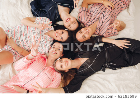 Top view relaxing young girl friends lying on bed 62183699