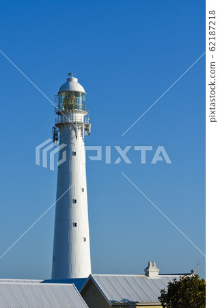 Tall White Lighthouse Tower Over Rooftops 62187218