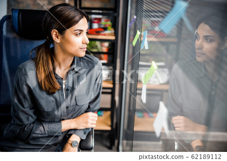 Attractive young brunette looking at her reflection Attractive young brunette looking at her reflection 62189112