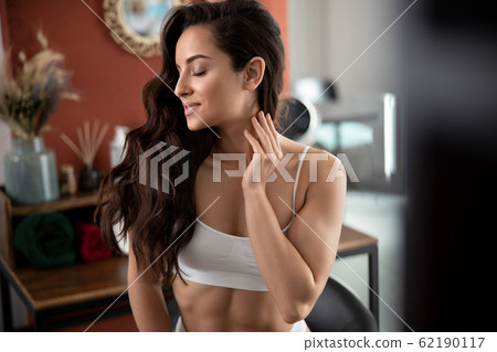 Gorgeous young woman with perfect skin touching neck Gorgeous young woman with perfect skin touching neck 62190117