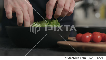 man preparing salad tearing frisee leaves man preparing salad tearing frisee leaves 62191221