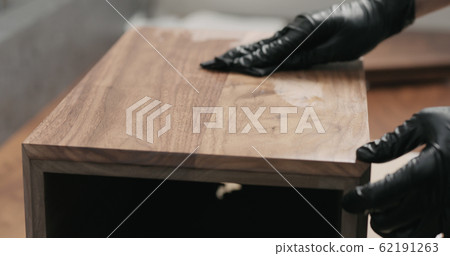 woodworker applying oil finish to black walnut storage box woodworker applying oil finish to black walnut storage box 62191263