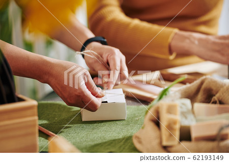 Women packing small soap bars 62193149