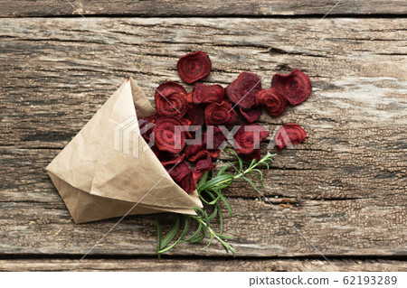 Homemade beetroot chips. Snacks are wrapped in a paper bag. Handmade healthy vegetable chips. Natural healthy snack 62193289
