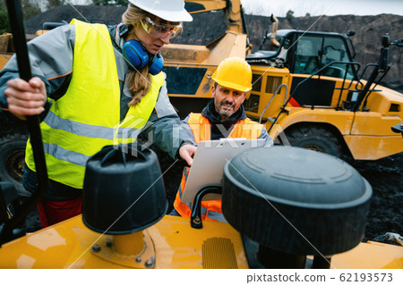 Woman and man worker in quarry on excavation machine Woman and man worker in quarry on excavation machine 62193573
