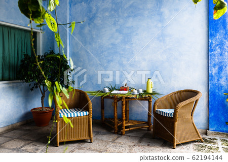 cozy sitting area in the shade with two rattan chairs, a table is set for tea cozy sitting area in the shade with two rattan chairs, a table is set for tea 62194144