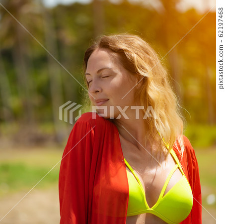 Stockfoto Bikini model girl posing sexy at tropical beach location, without  bra, closes a breast with leaf. Vogue style